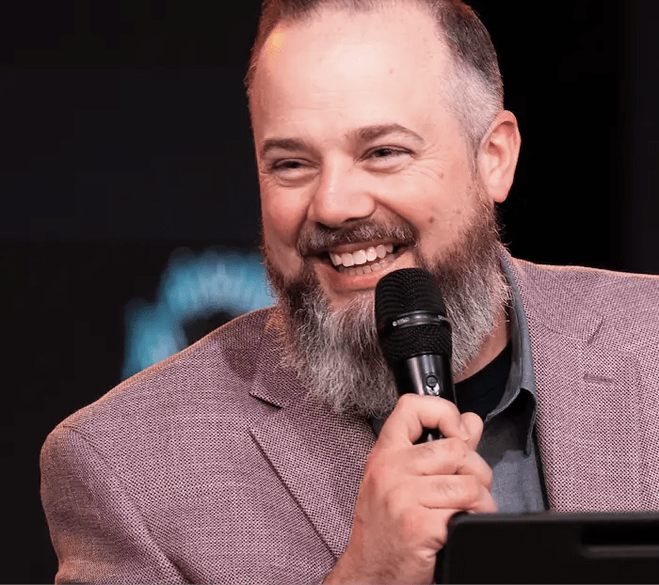 Bishop Alan DiDio smiling with a microphone