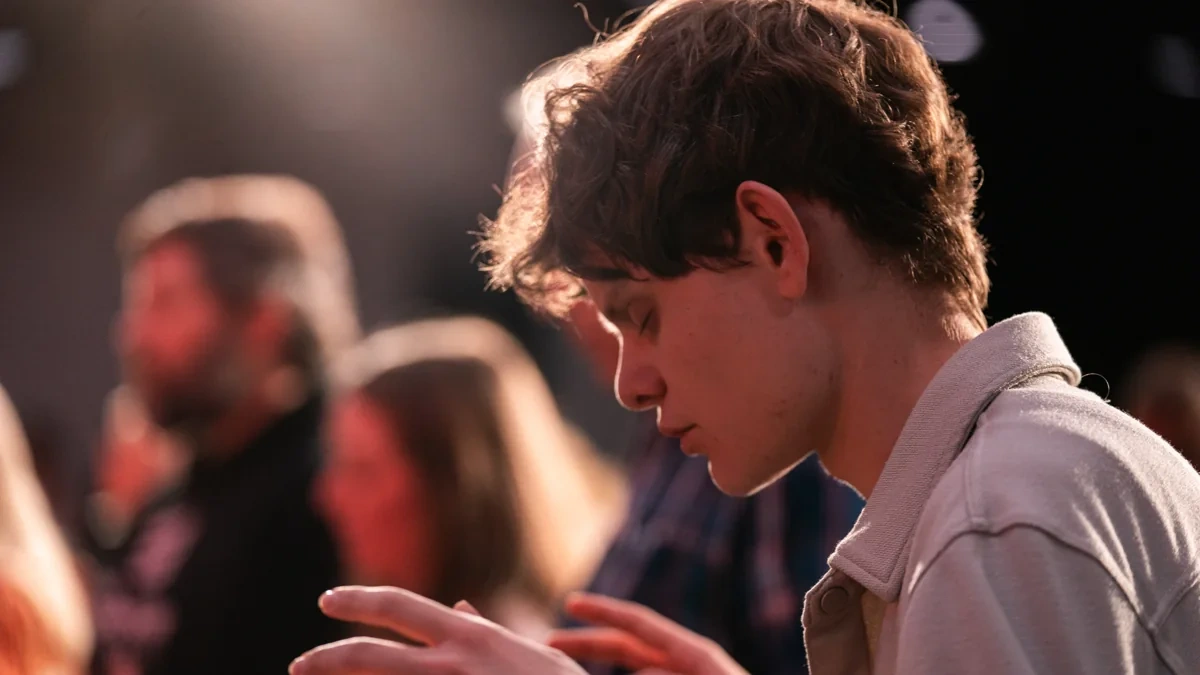 A young person praying during the youth service